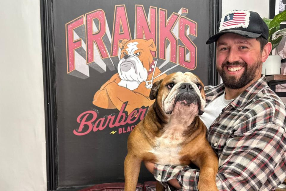 Frank's Barbershop owner with the shop artwork
